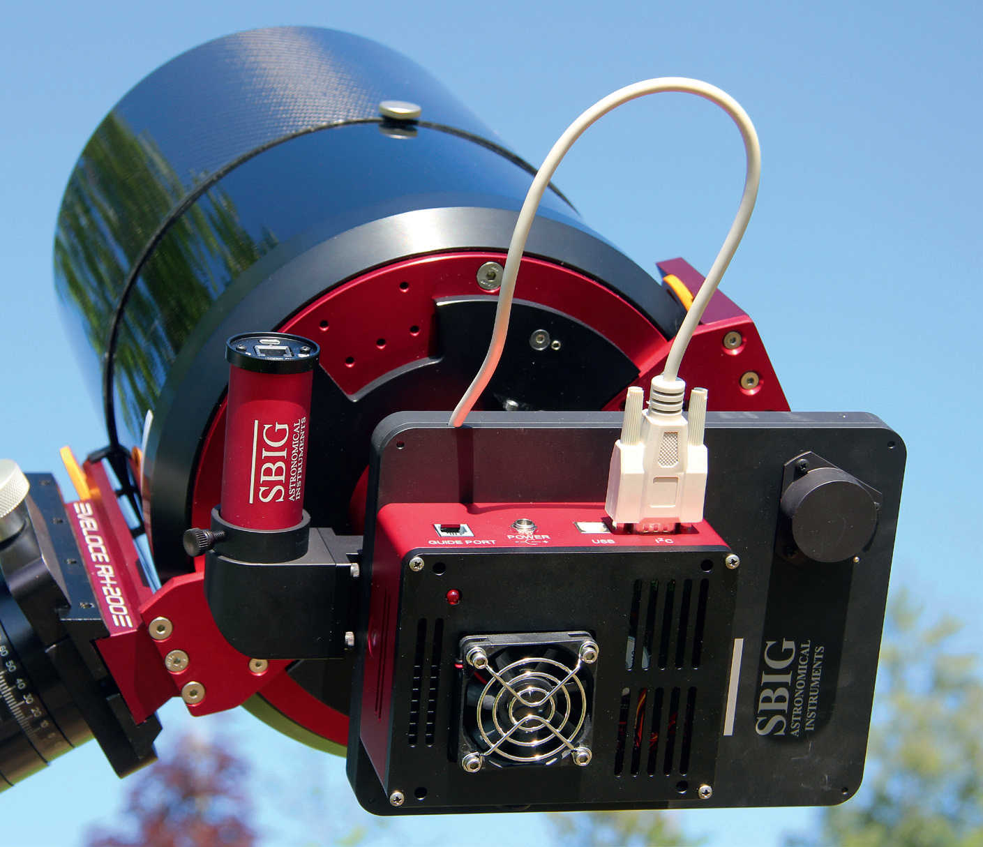 En kyld CCD-kamera på en astrograf: Filterhjulet (också svart) syns mellan teleskopet och kameran (rödsvart kåpa) och bredvid den en rund guidekamera
(röd), som är ansluten till teleskopets strålgång via en off-axis guider. U. Dittler