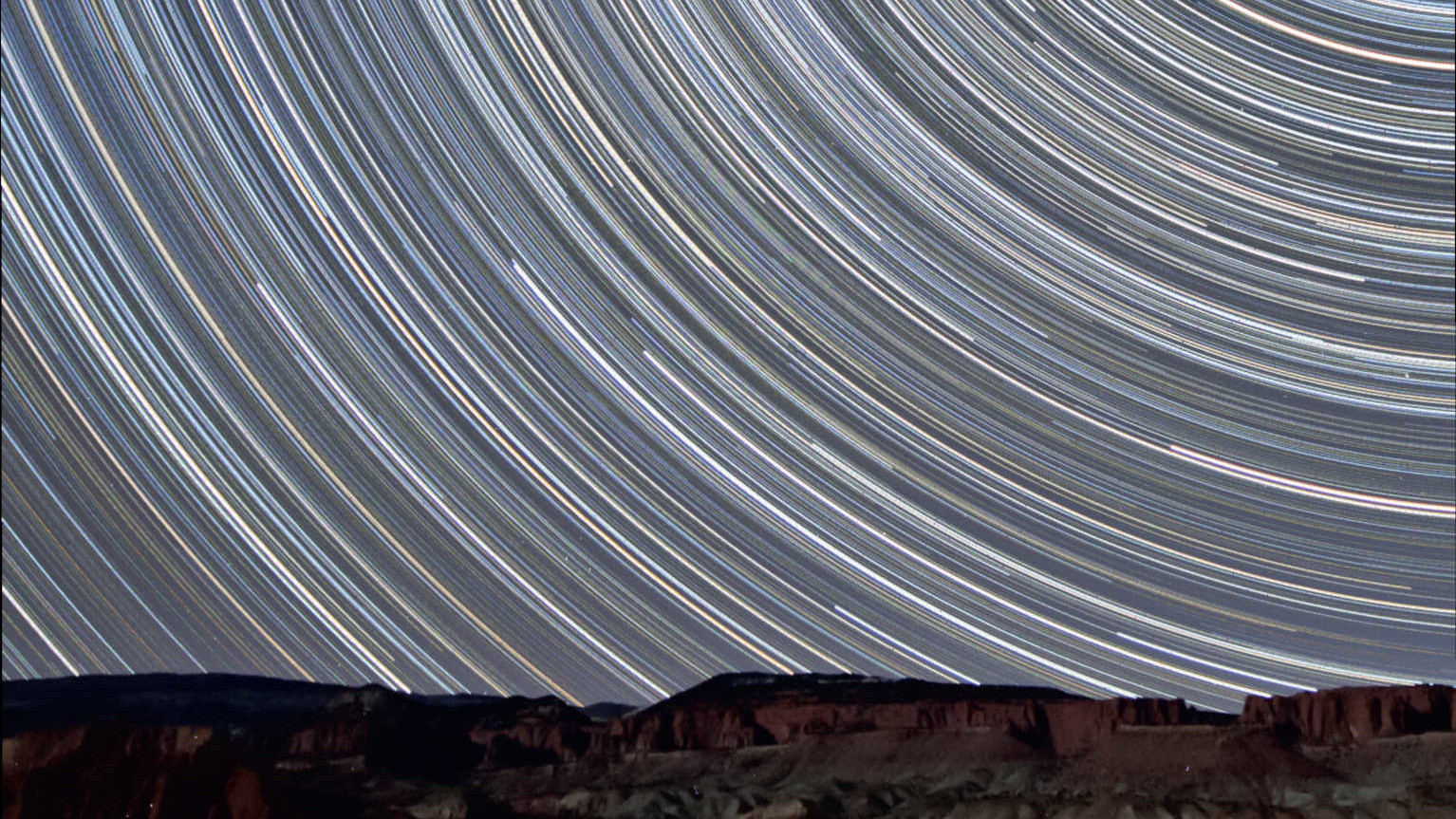 Några få mil från Capitol Reef Nationalpark i Utah (USA) togs dessa stjärnspårsbilder med utsikt mot norr. De visar stjärnornas förflyttning över de av den tilltagande månen upplysta röda sandstensklipporna. I denna summerade bild kombineras 350 exponeringar med en varaktighet av 90 sekunder vardera (total exponeringstid: 525 minuter = 8,75 timmar). Bilden togs med ett 10–20 mm objektiv (vid 10 mm och f/4) på en Canon DSLR av modell 450D. U. Dittler