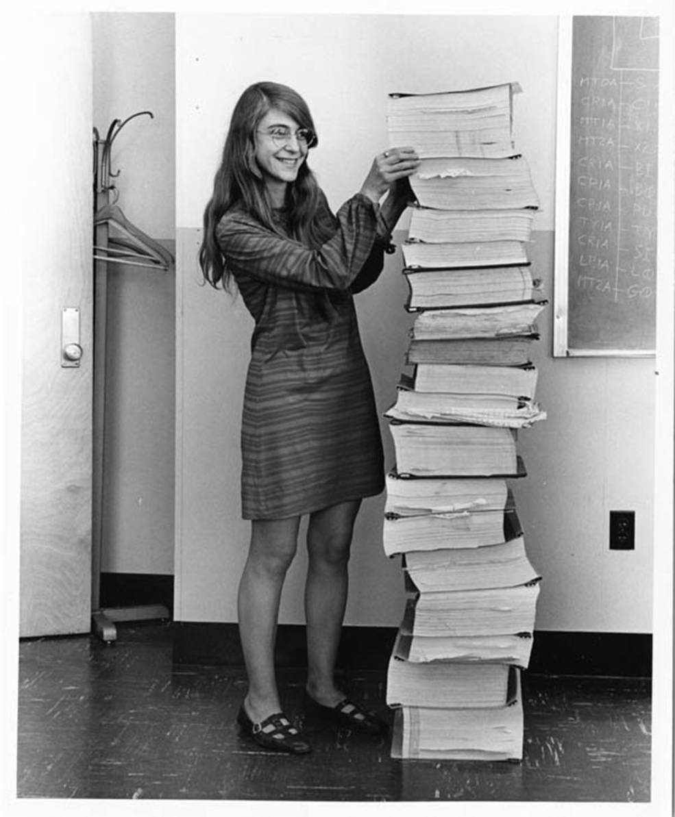 Margaret Hamilton bredvid en stapel med källkod för Apollo Guidance Computer. © Med tillstånd av MIT Museum